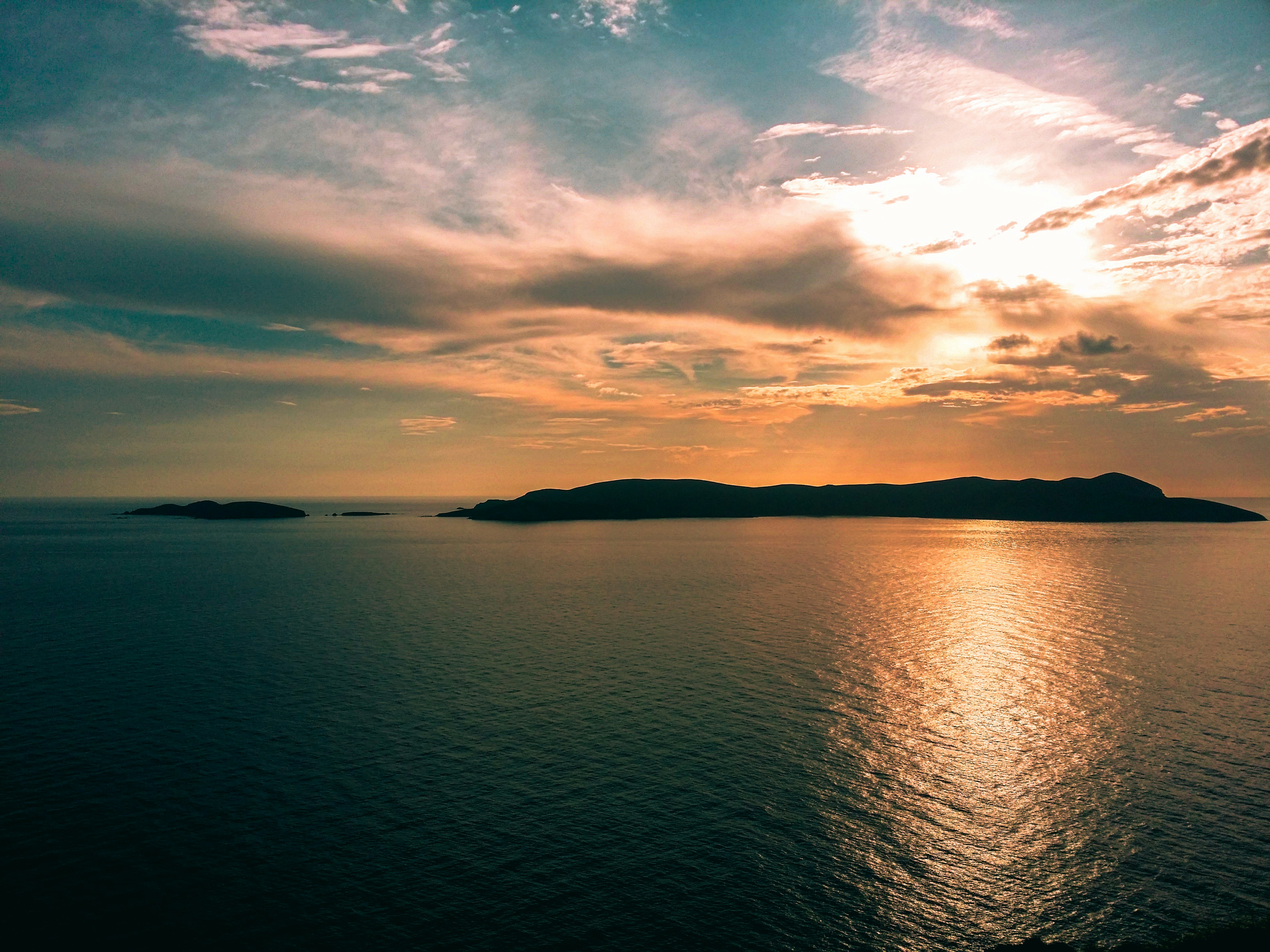 body of water under cloudy sky during sunset